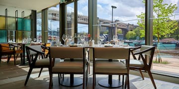 a table with chairs and glasses in a restaurant