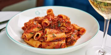 a plate of pasta with sauce and wine