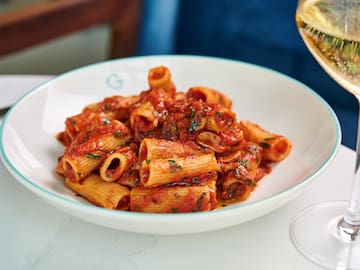 a plate of pasta with sauce and wine