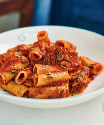 a plate of pasta with sauce and wine