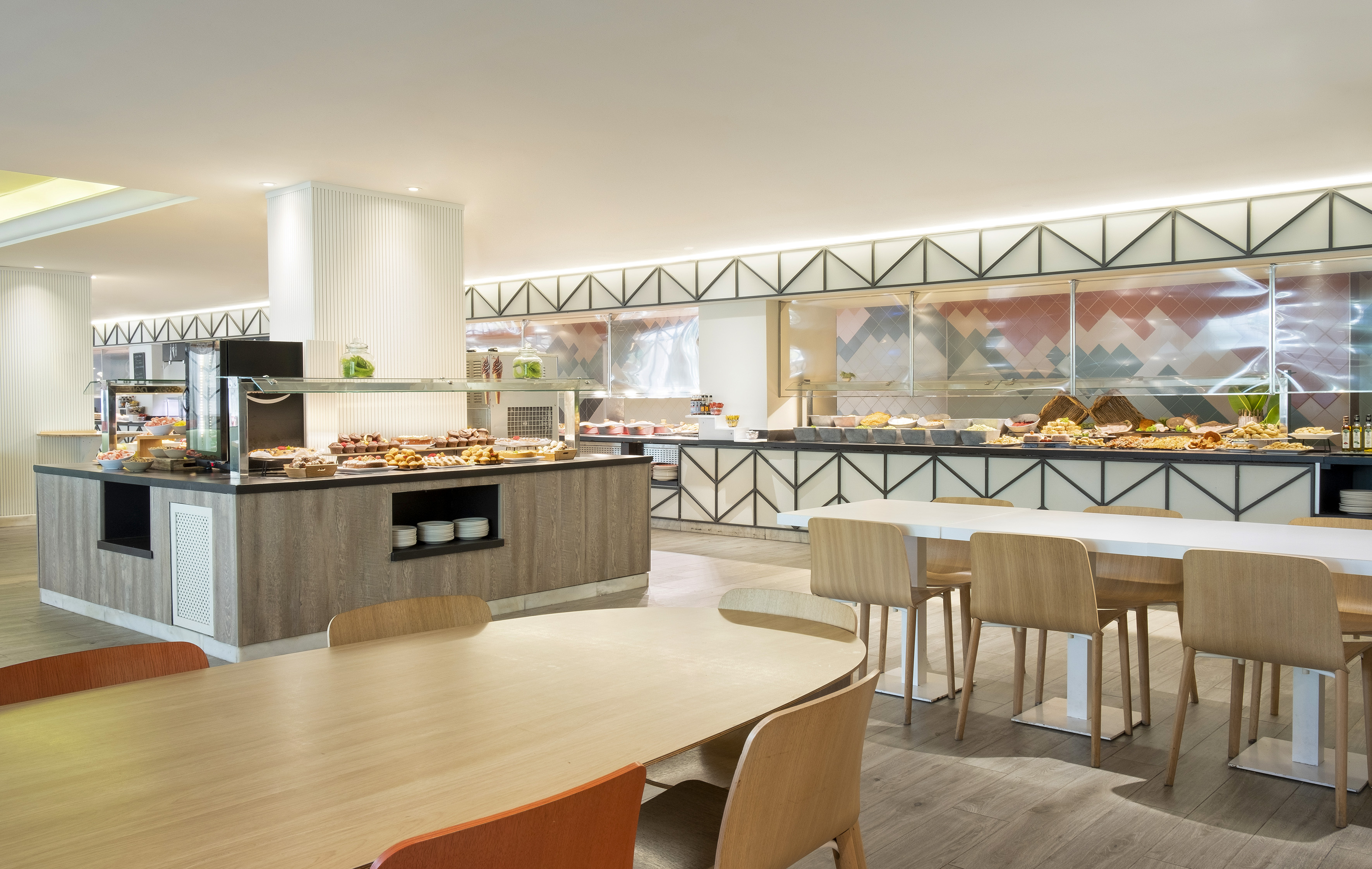 Modern hotel buffet breakfast restaurant with a large food spread.