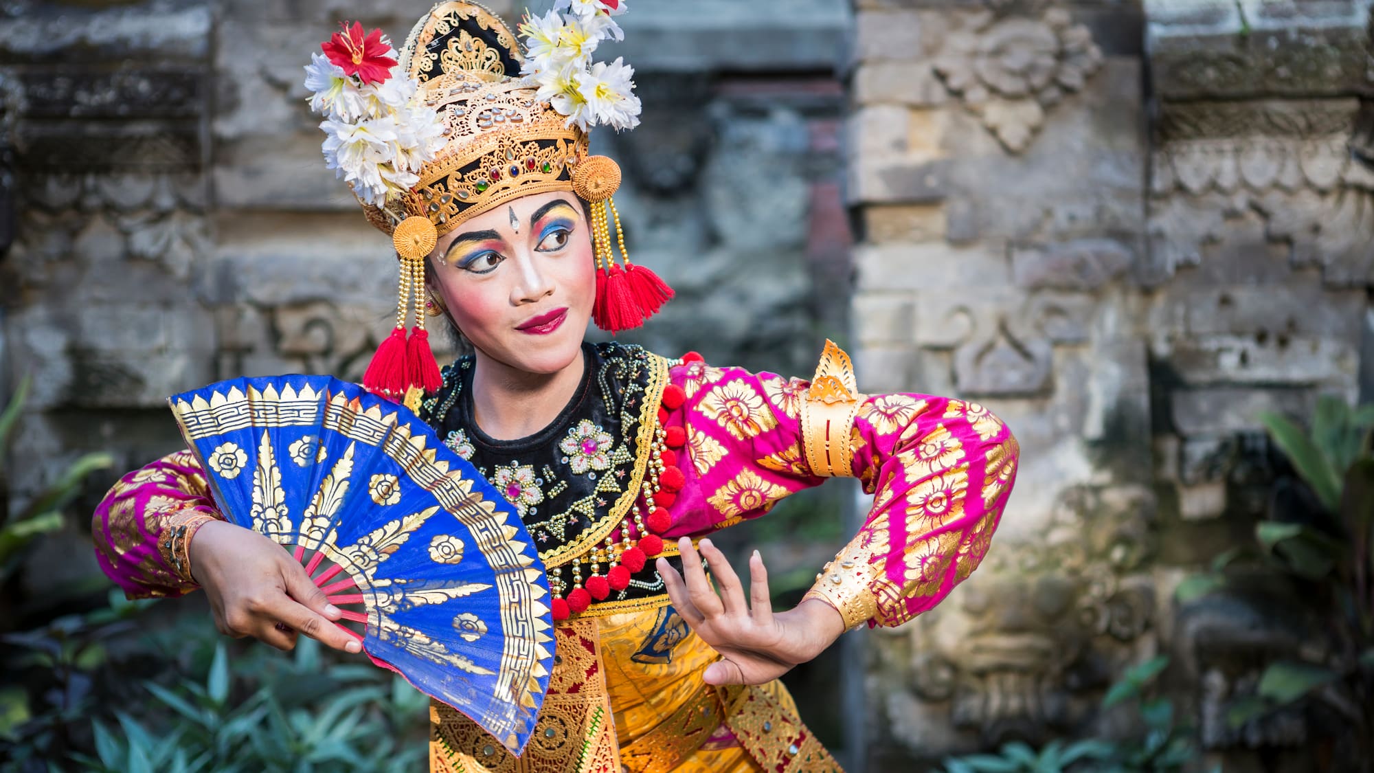 a woman in traditional garment holding a fan