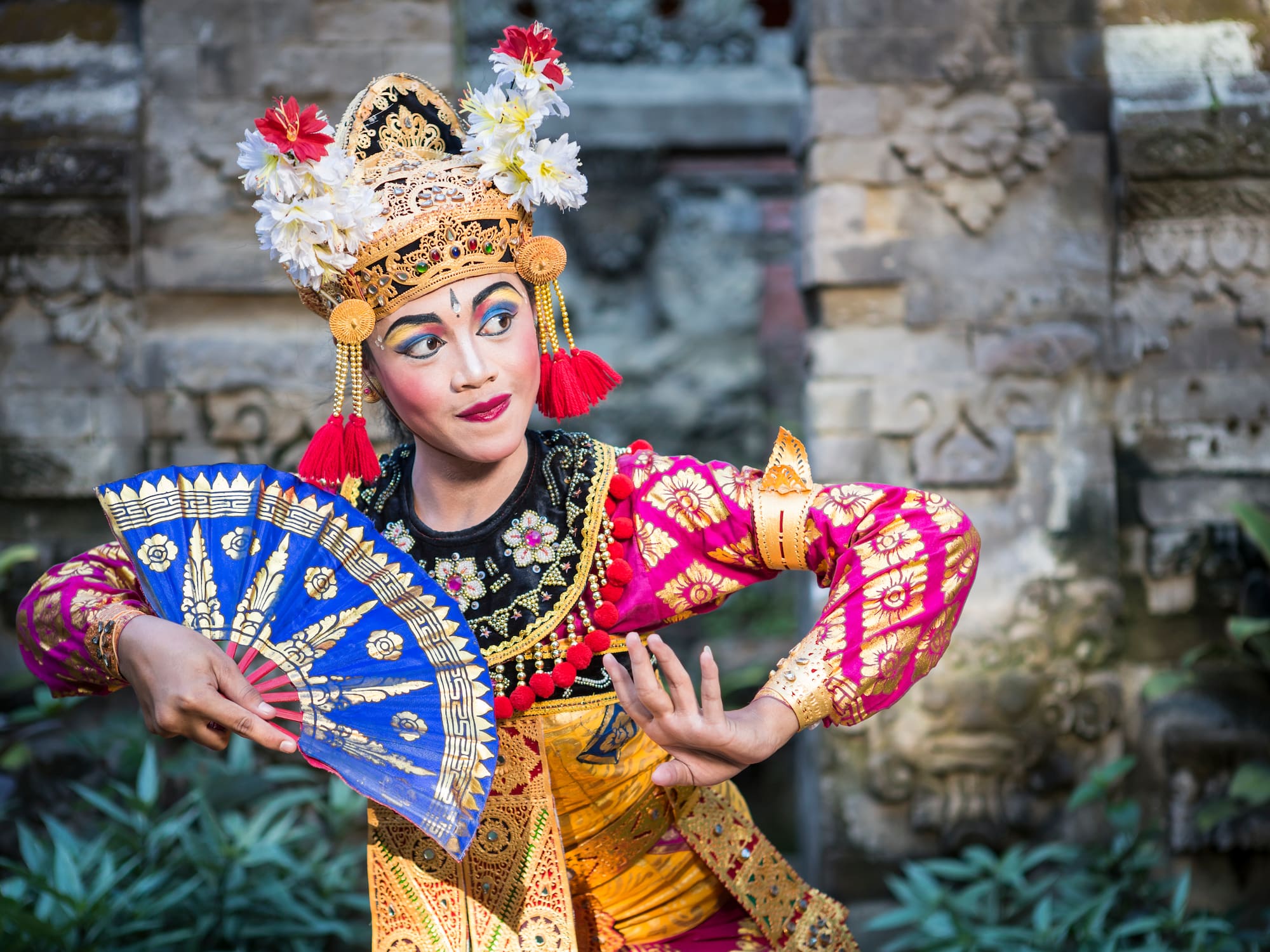 a woman in traditional garment holding a fan
