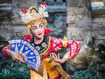 a woman in traditional garment holding a fan