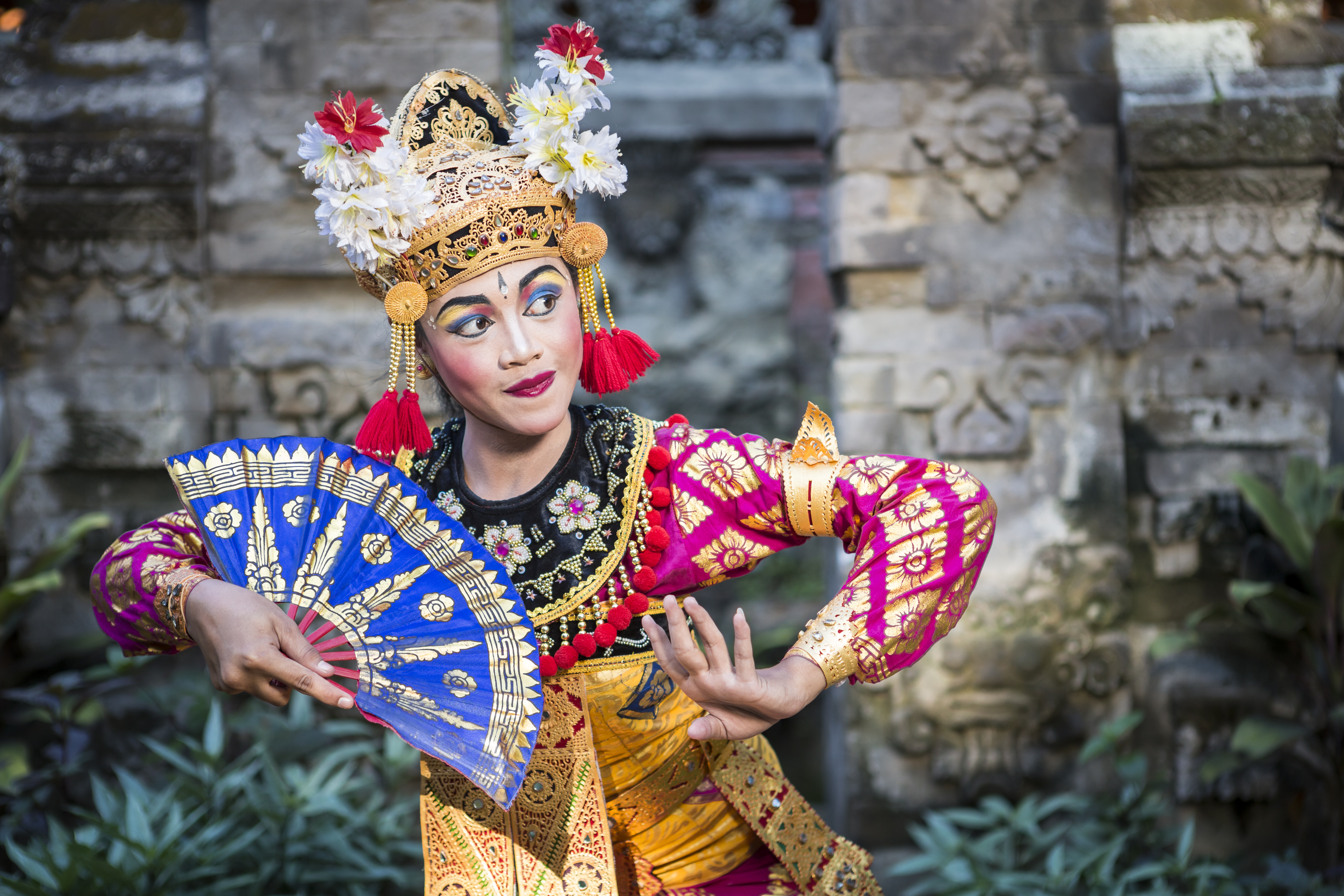 a woman in traditional garment holding a fan