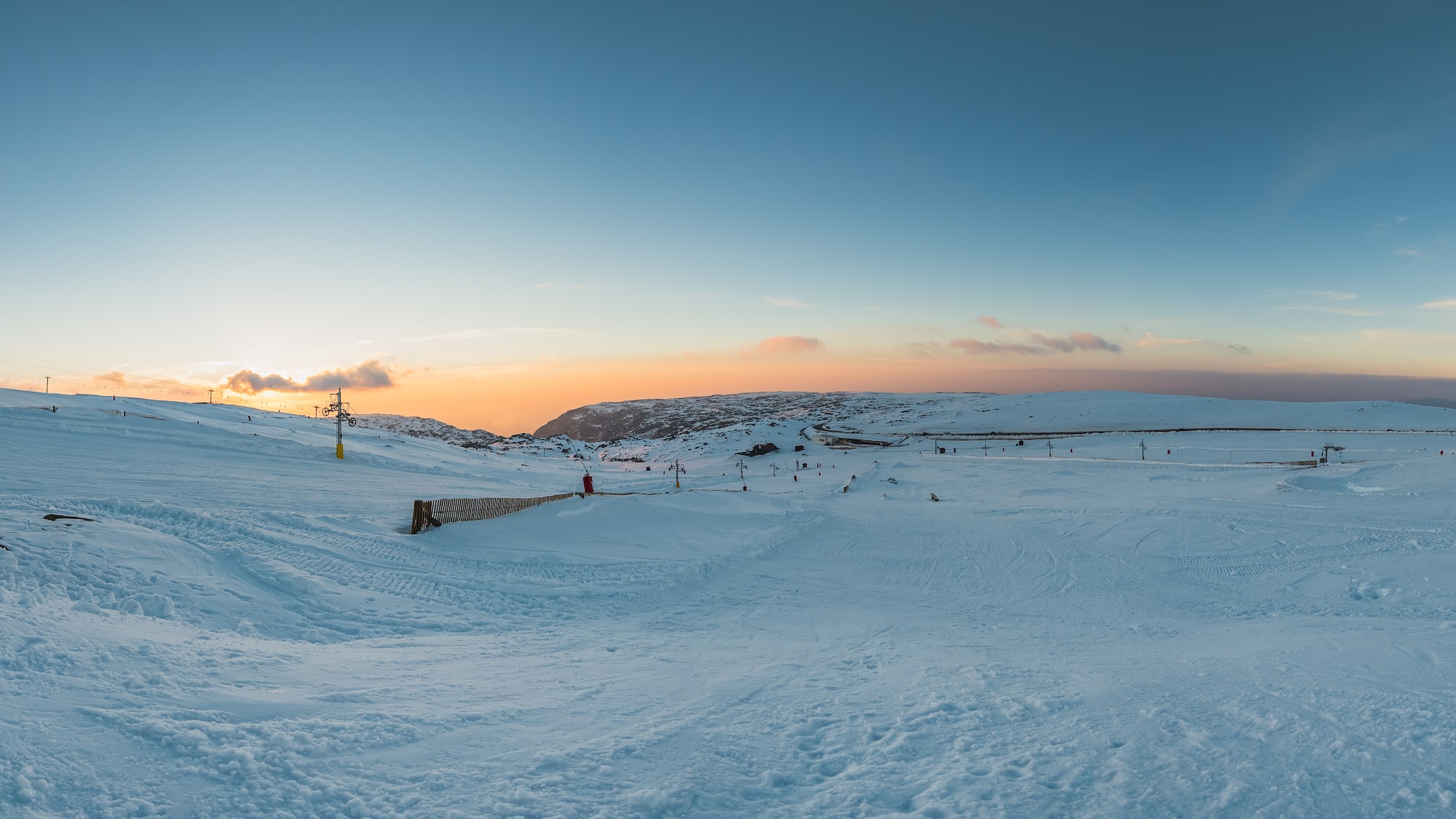 a snow covered field with people skiing