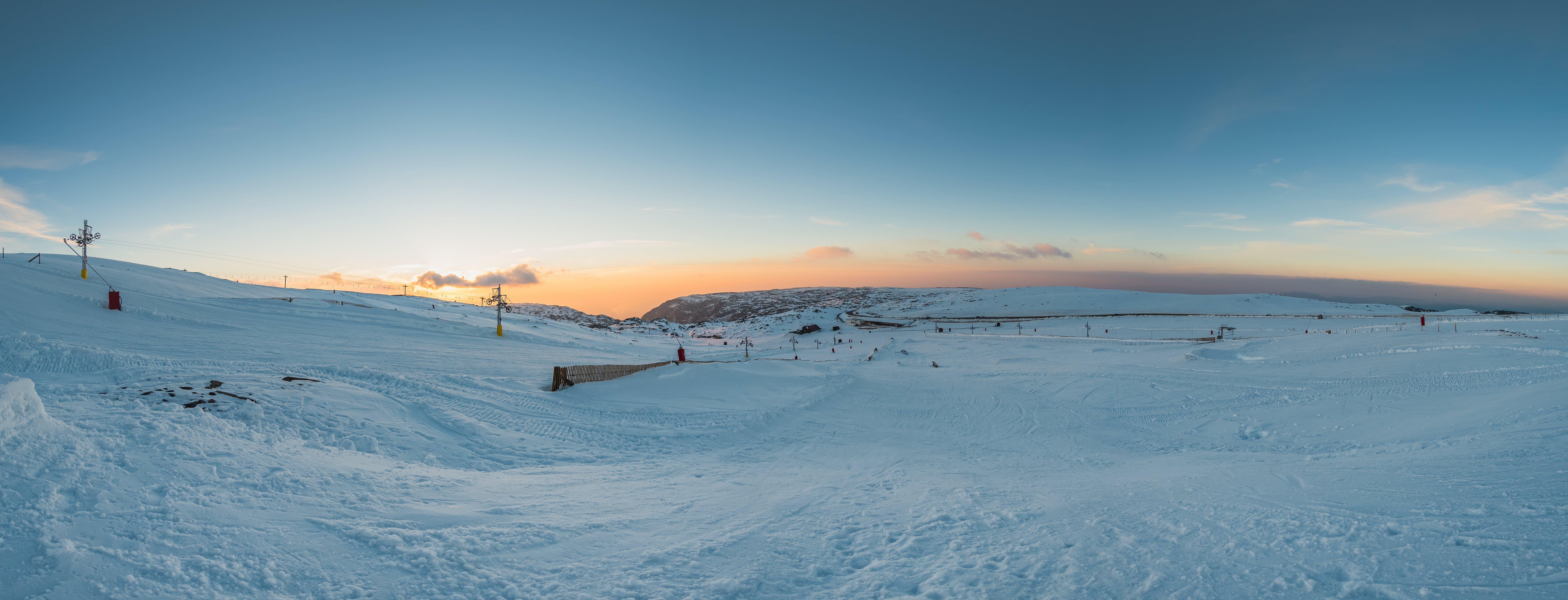 a snow covered field with people skiing