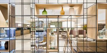 a glass wall with a shelf and a shelf with a chair and a table