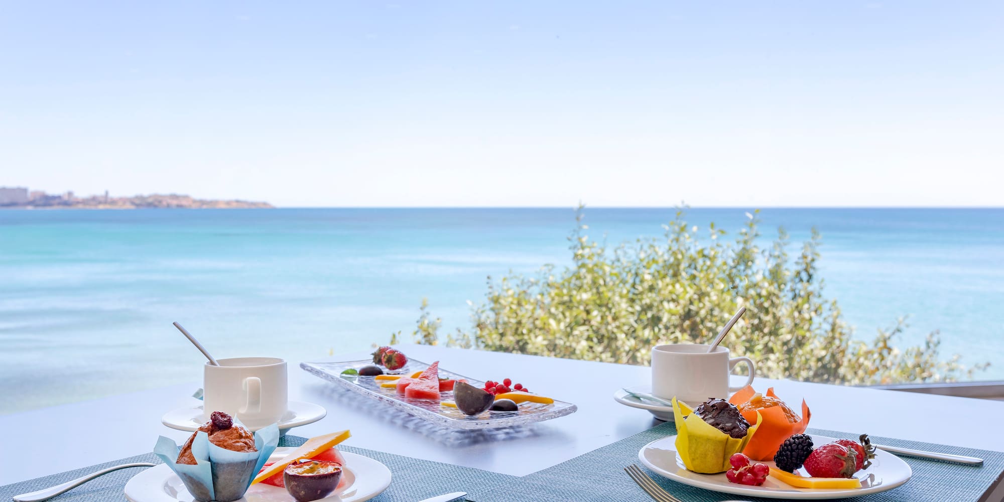 a table with plates of food and a cup of coffee on it