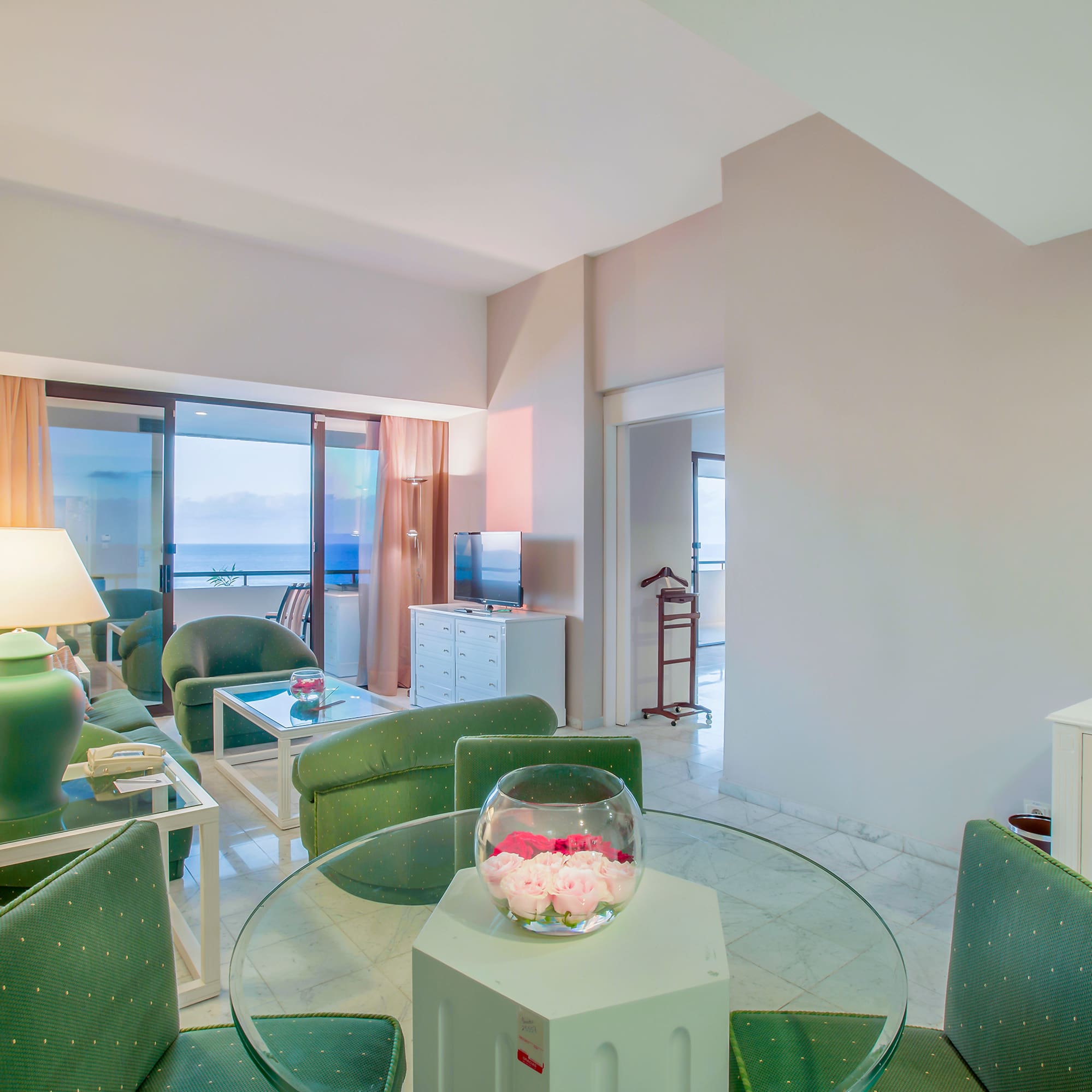 a room with green chairs and a glass table