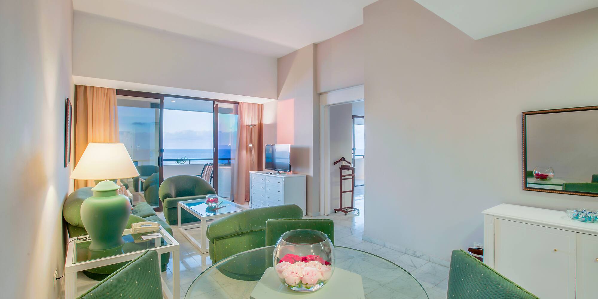 a room with green chairs and a glass table