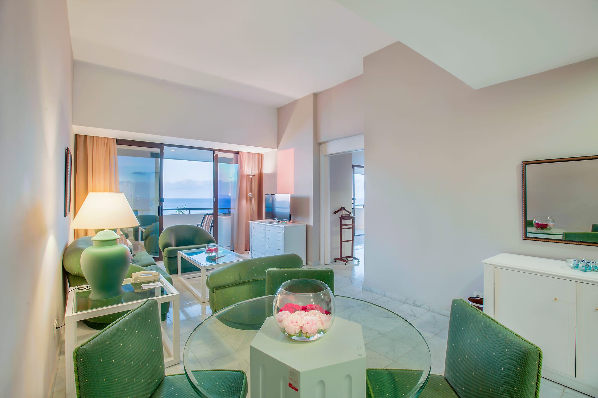 a room with green chairs and a glass table