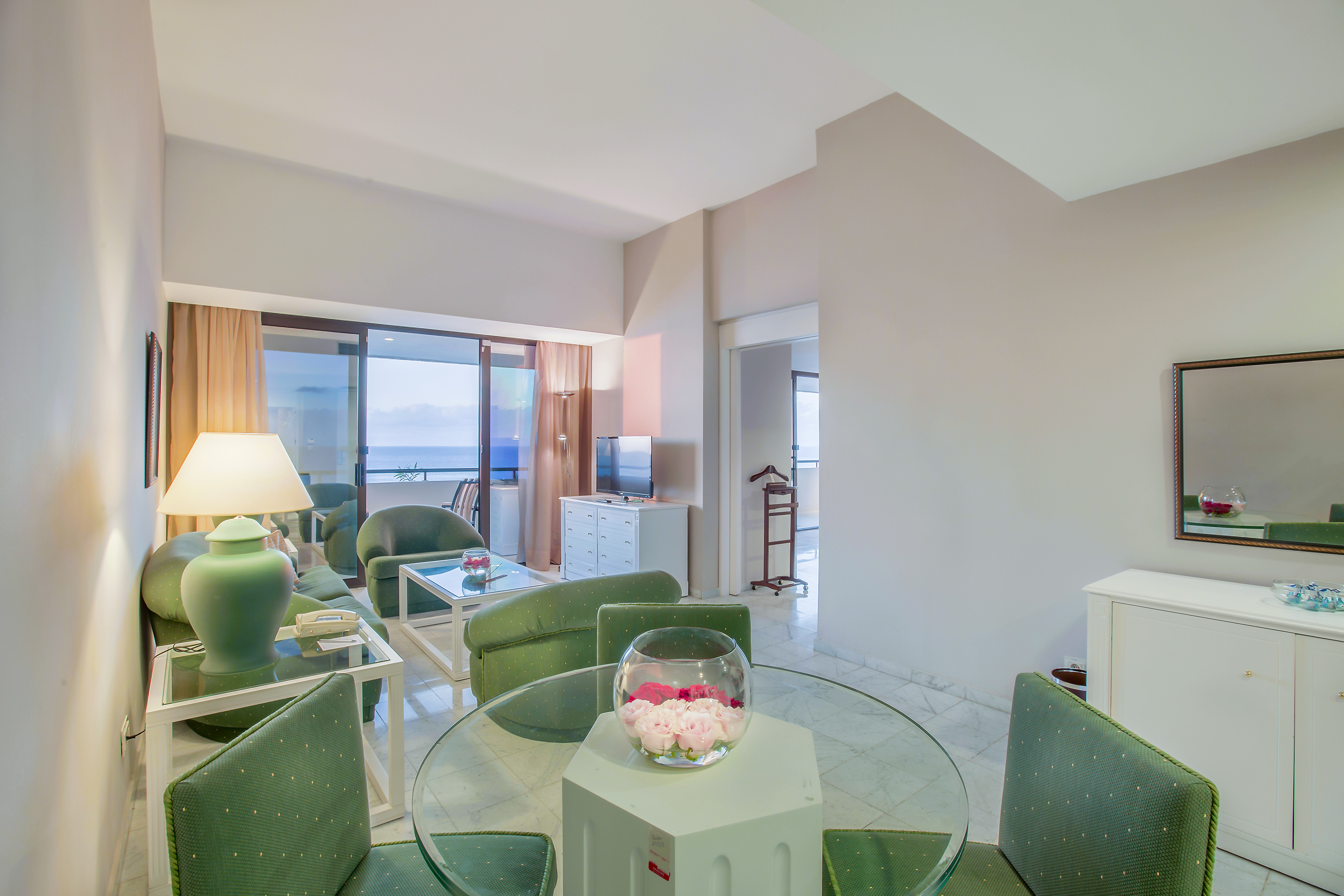 a room with green chairs and a glass table