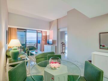a room with green chairs and a glass table