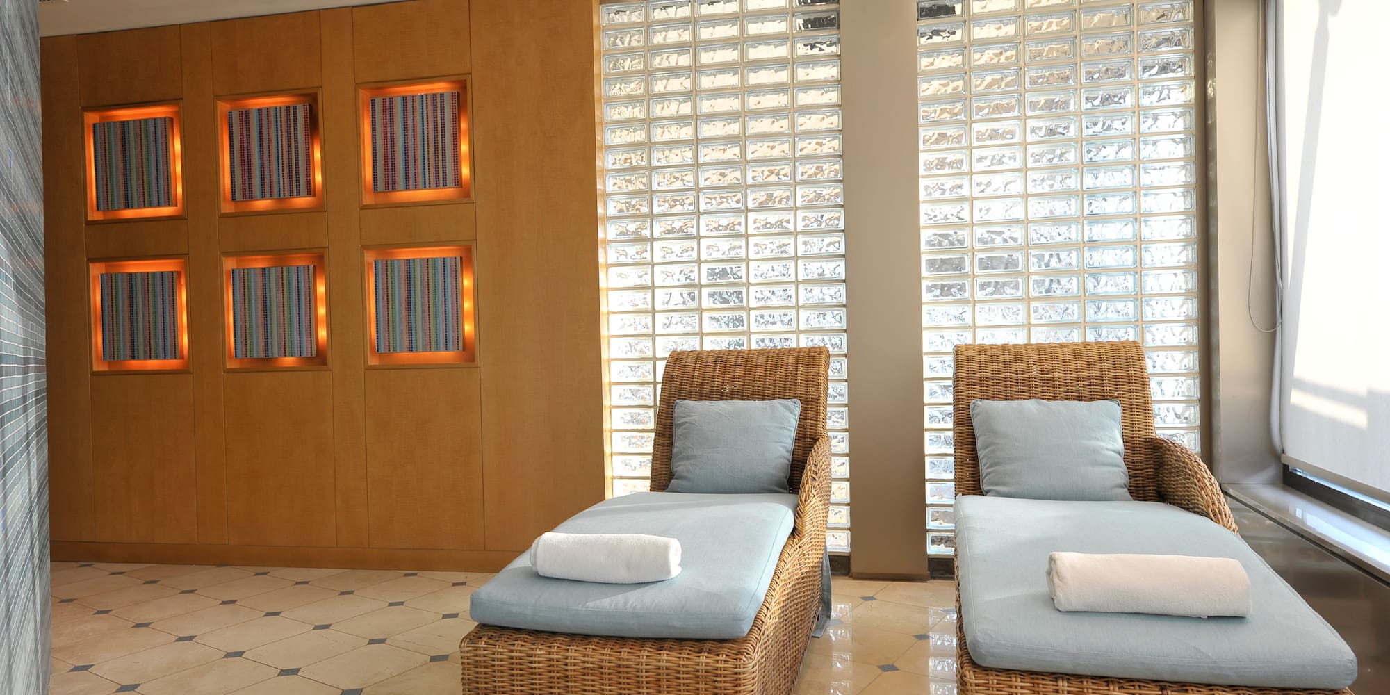 a room with chairs and a wall of glass blocks