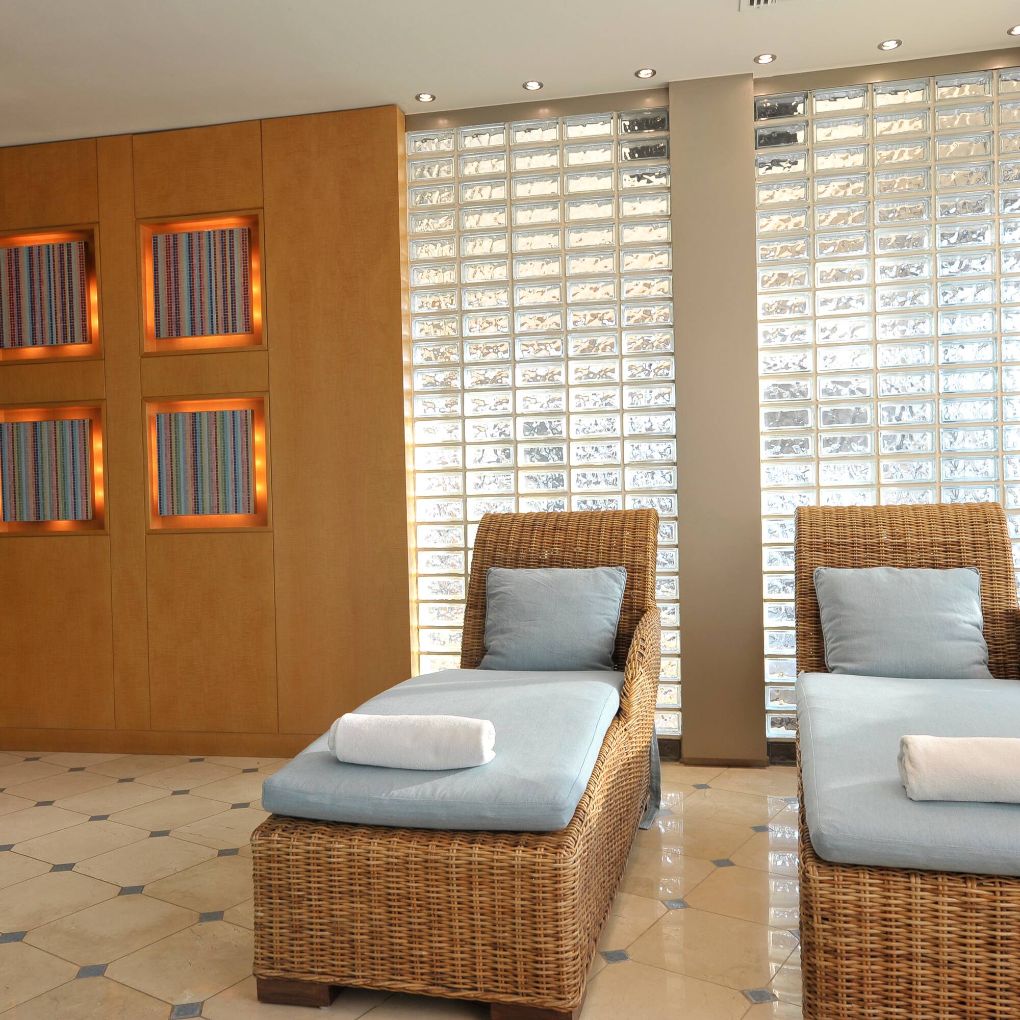 a room with chairs and a wall of glass blocks