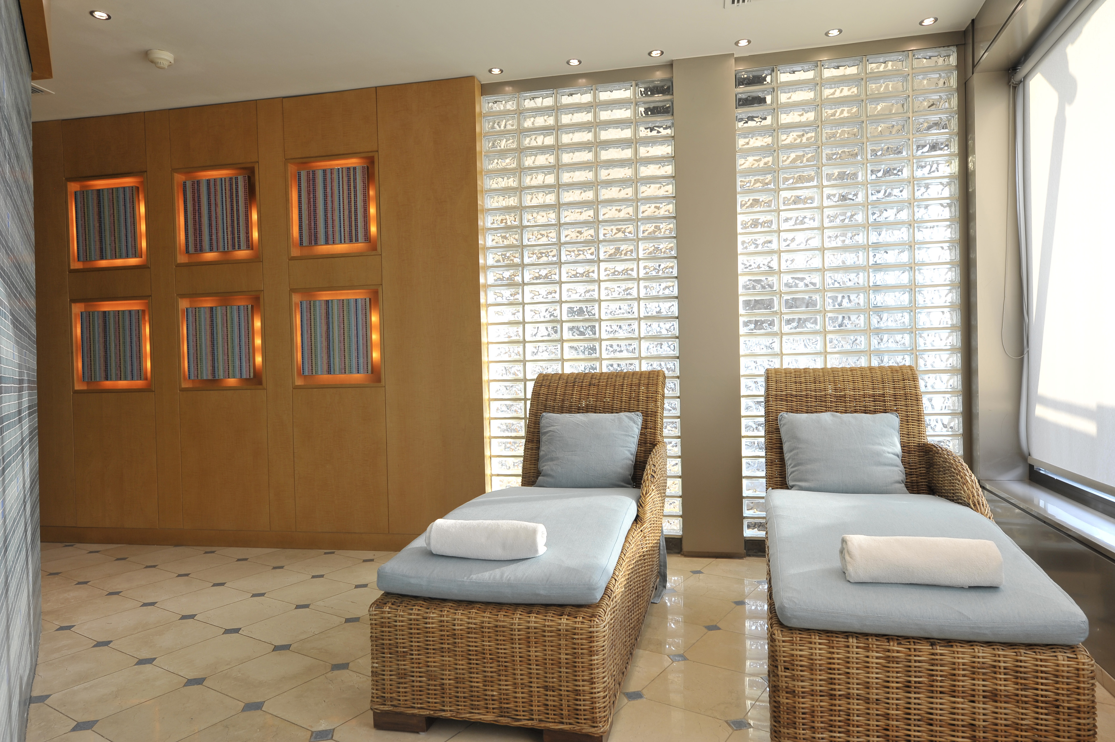 a room with chairs and a wall of glass blocks