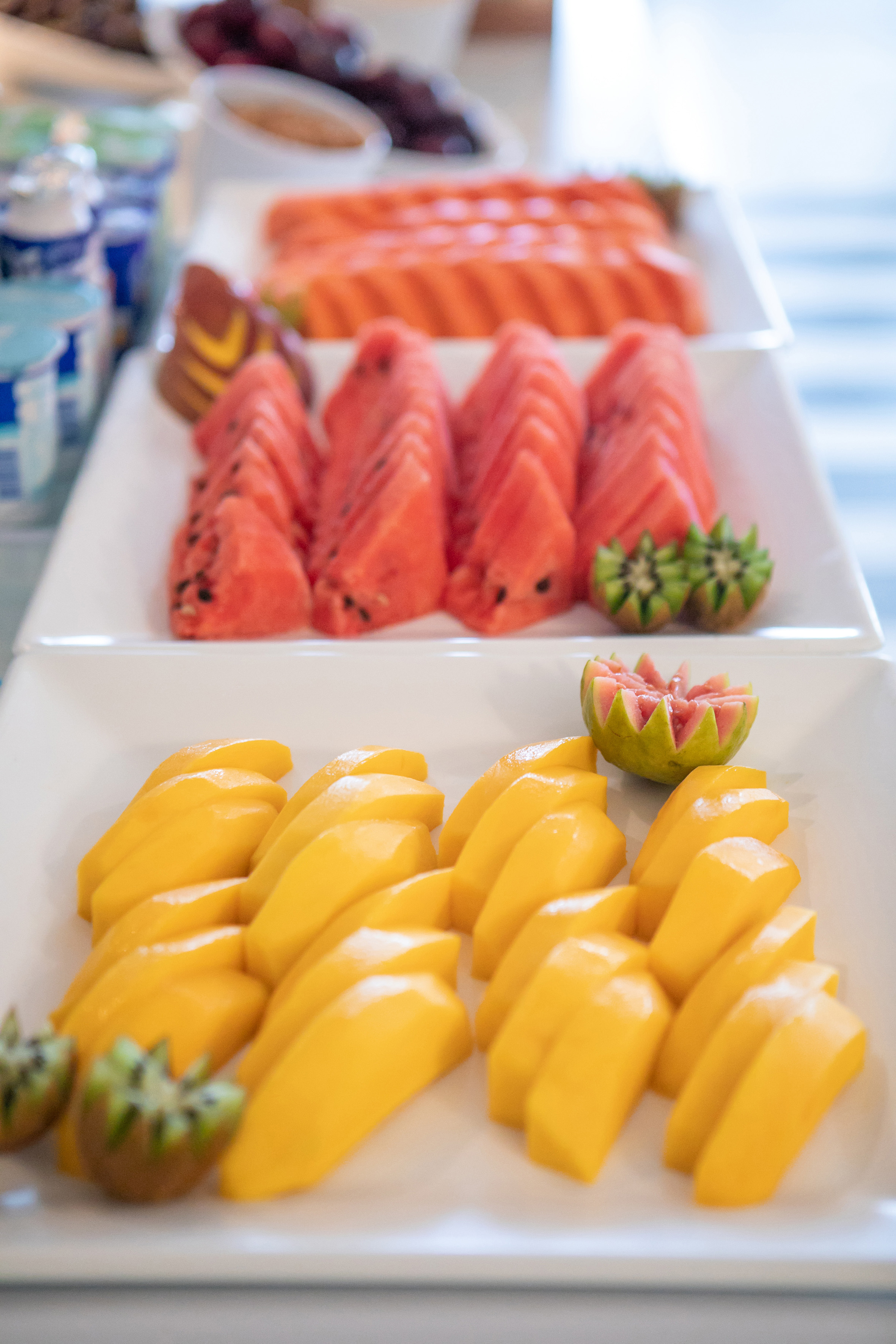 Fresh fruit buffet with sliced mango, watermelon, papaya, kiwi, and guava.