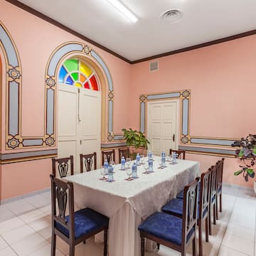 a table with chairs and a white tablecloth in a room with a pink wall