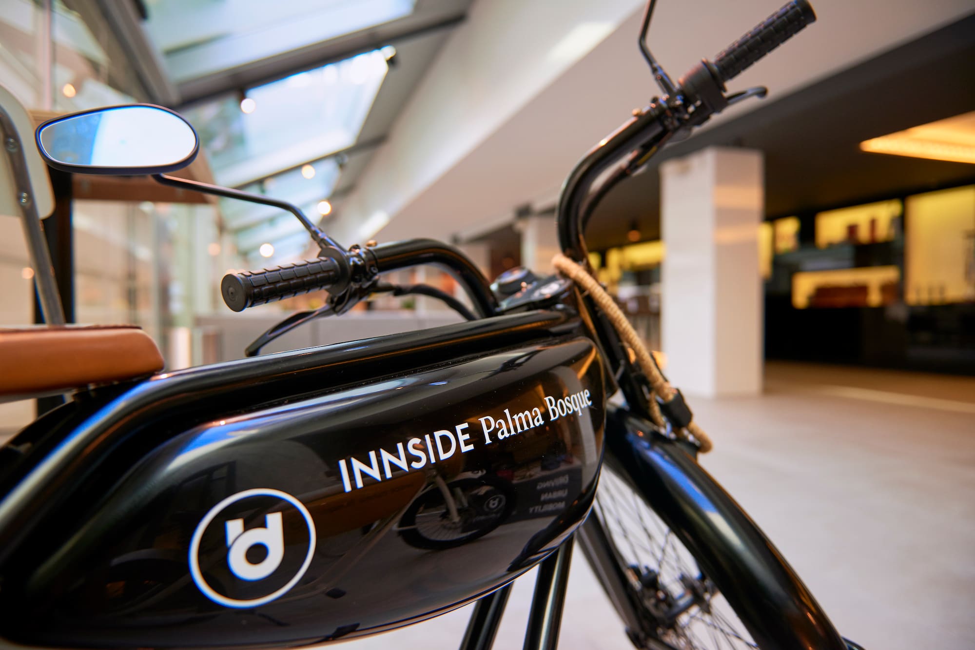 Black INNSIDE Palma Bosque e-bike with brown seat and logo, modern hotel transport.