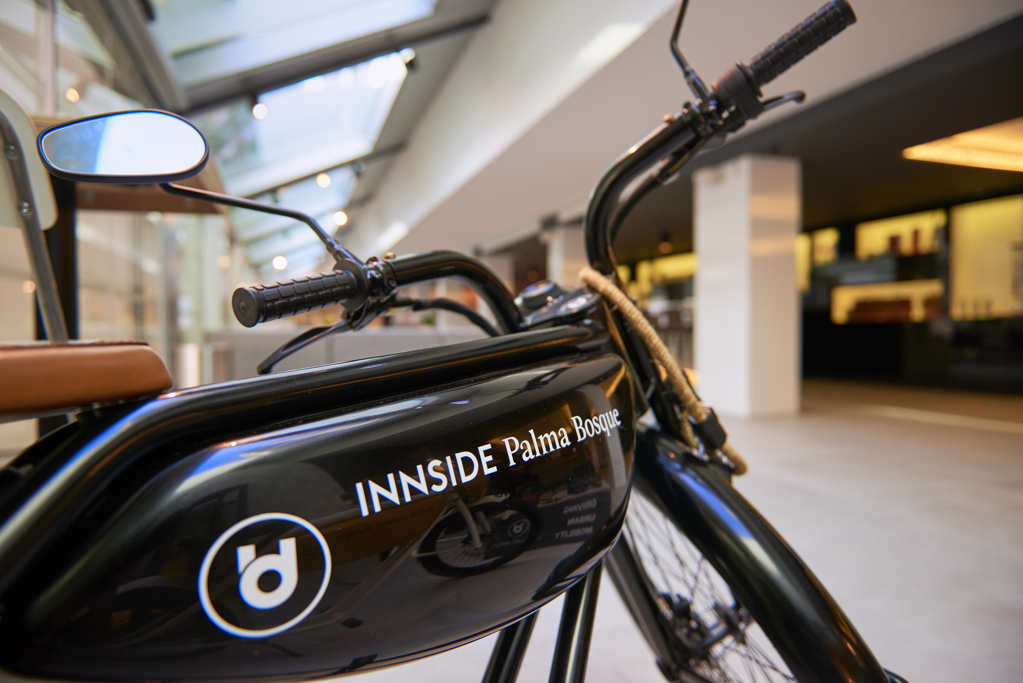 Black INNSIDE Palma Bosque e-bike with brown seat and logo, modern hotel transport.