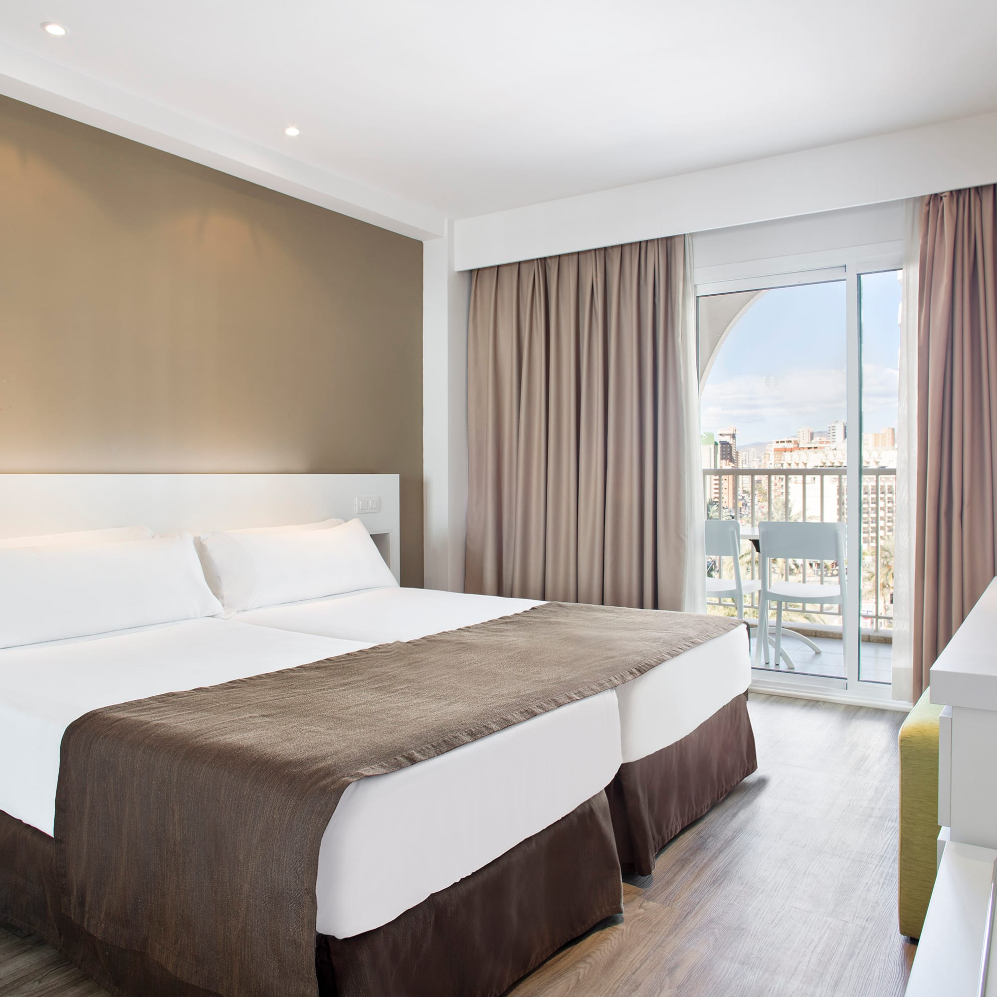 a room with two beds and a glass door