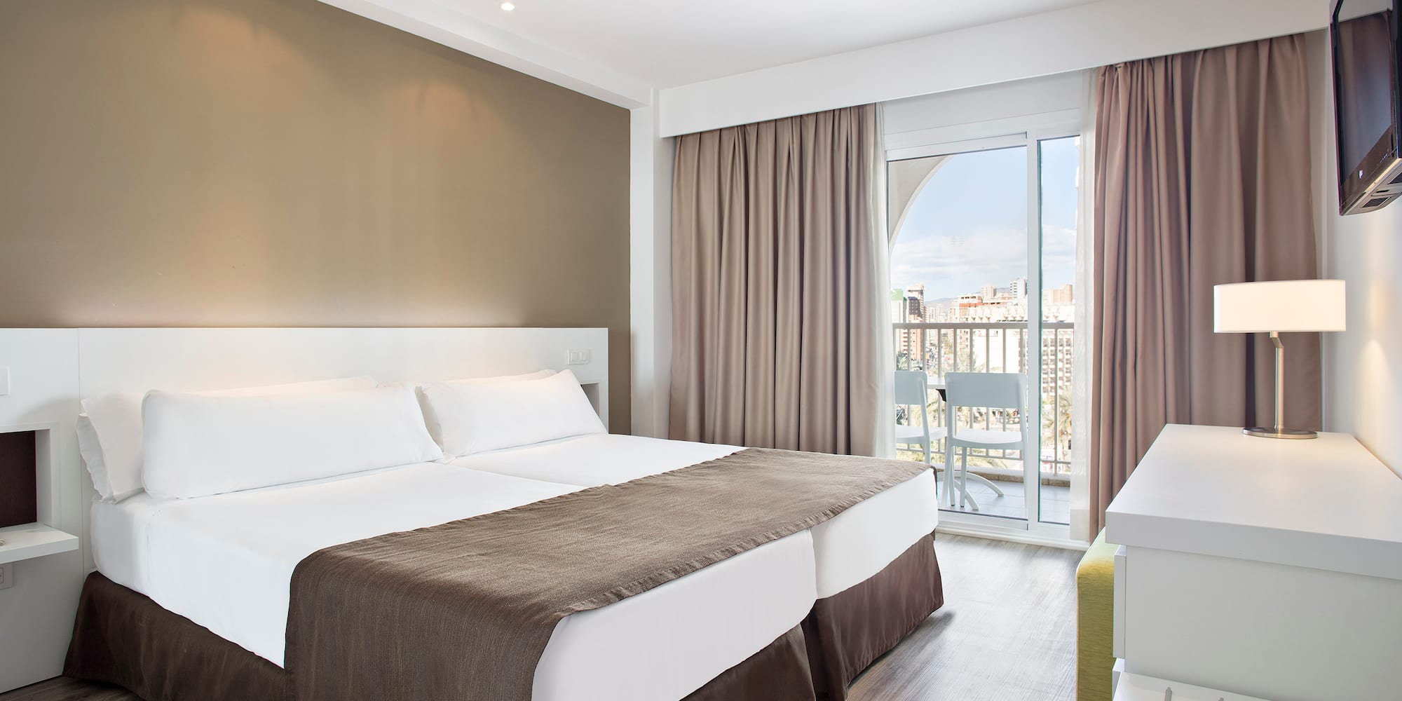 a room with two beds and a glass door