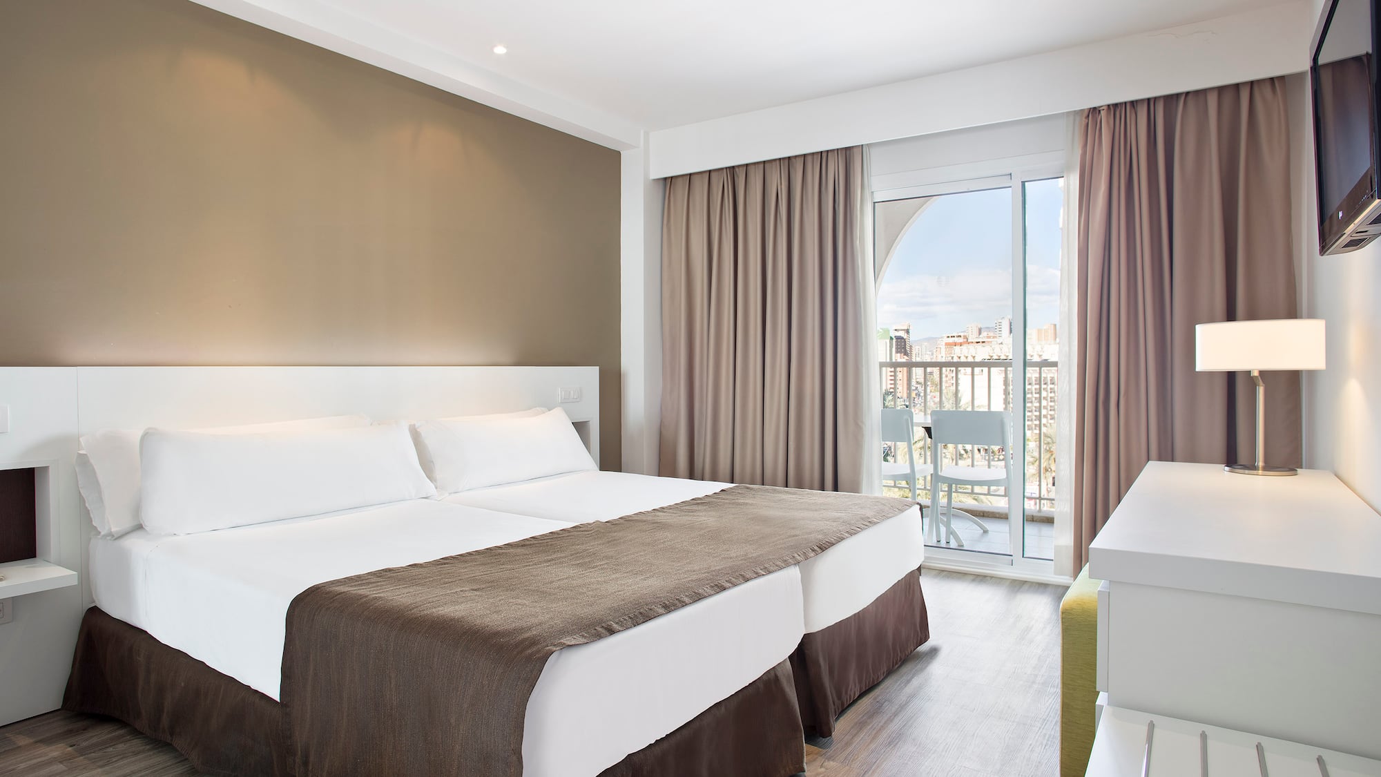 a room with two beds and a glass door