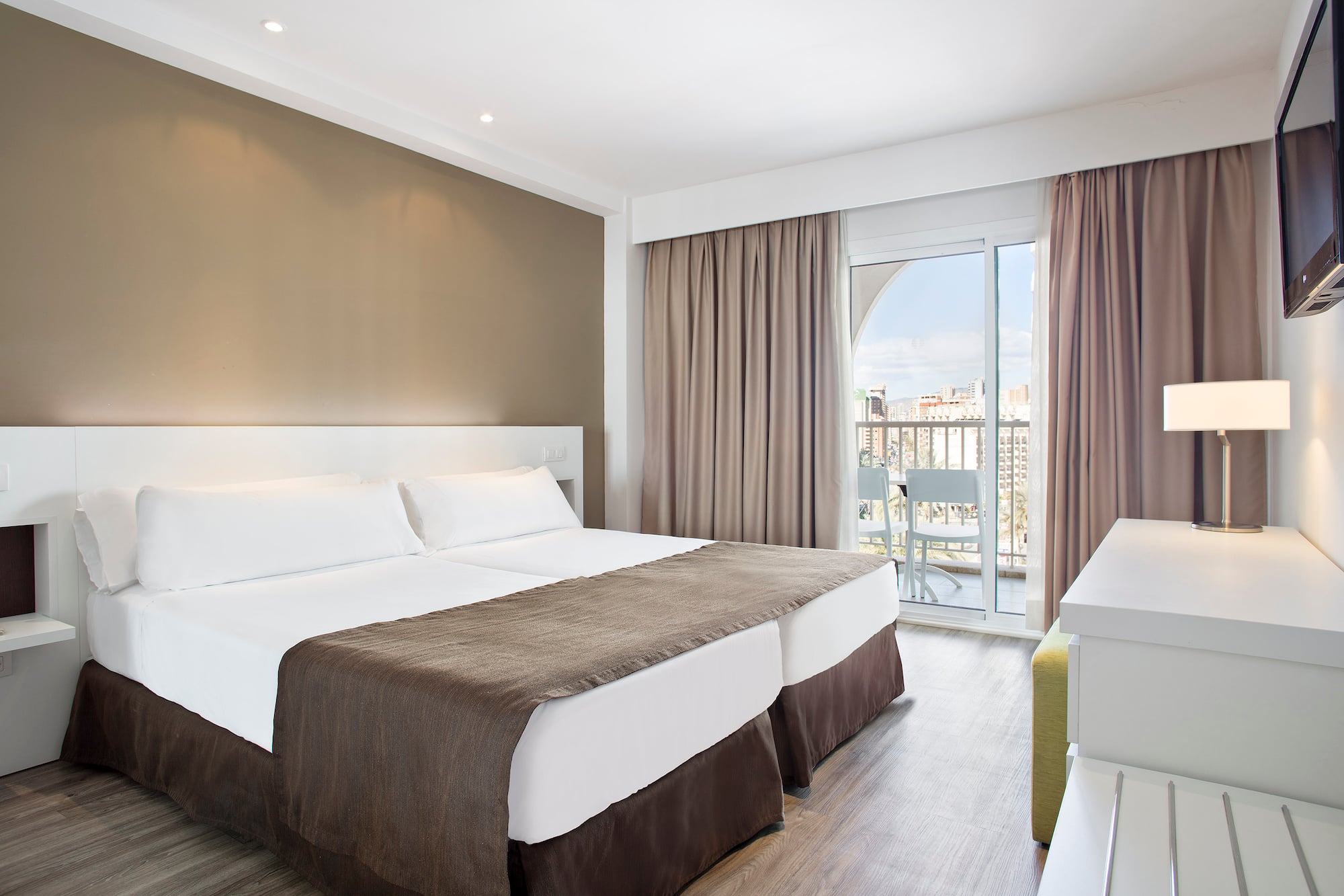 a room with two beds and a glass door