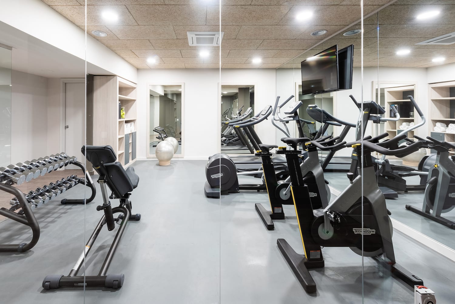 a room with exercise bikes and a television