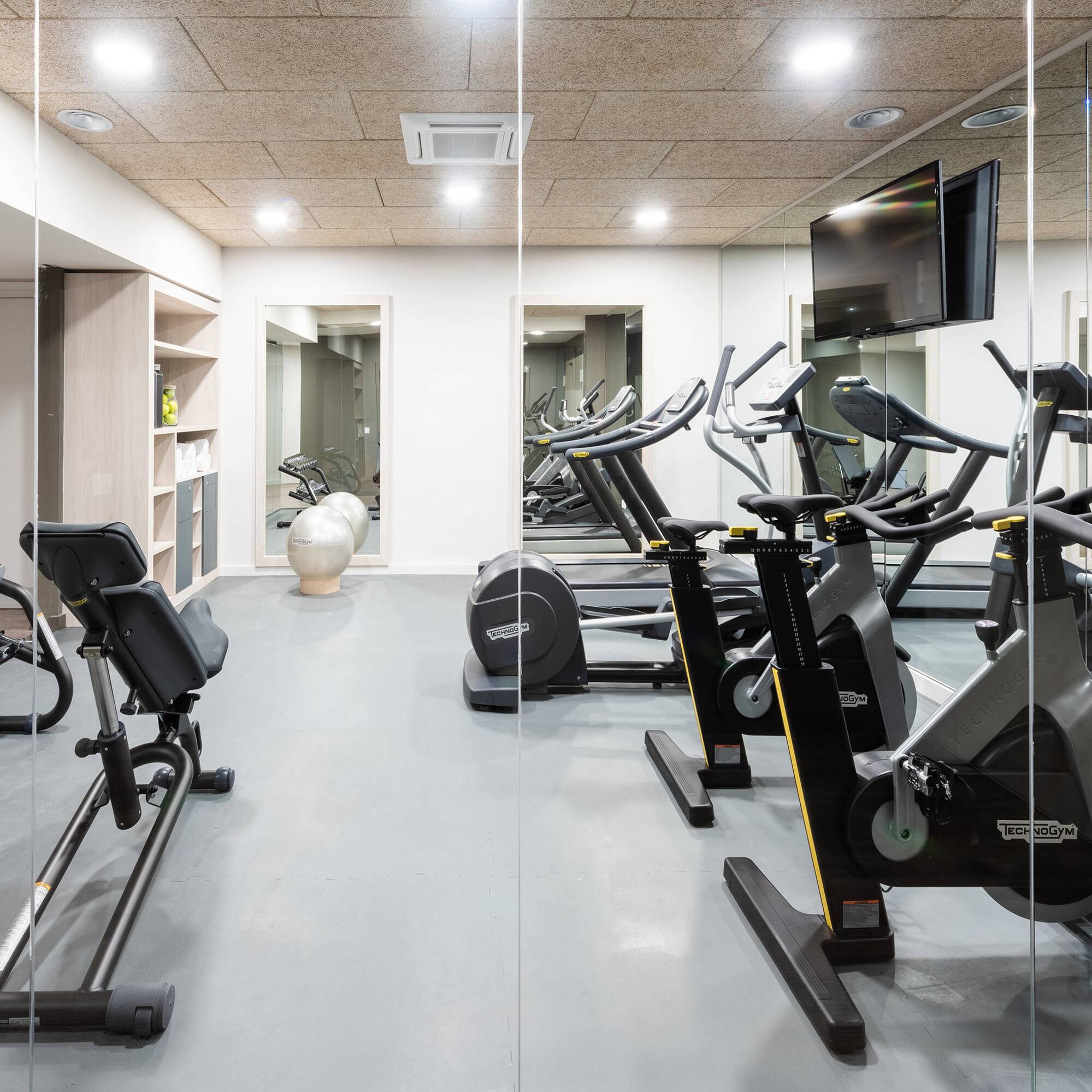 a room with exercise bikes and a television