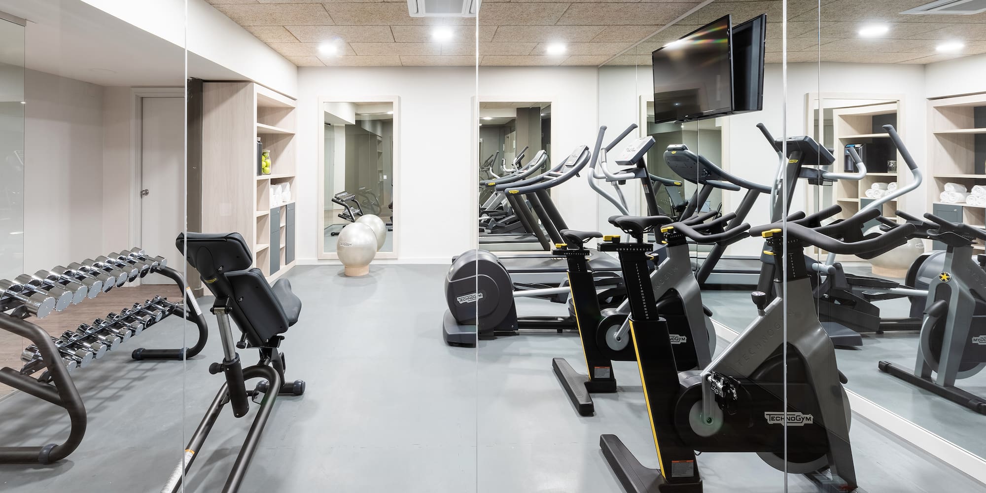 a room with exercise bikes and a television