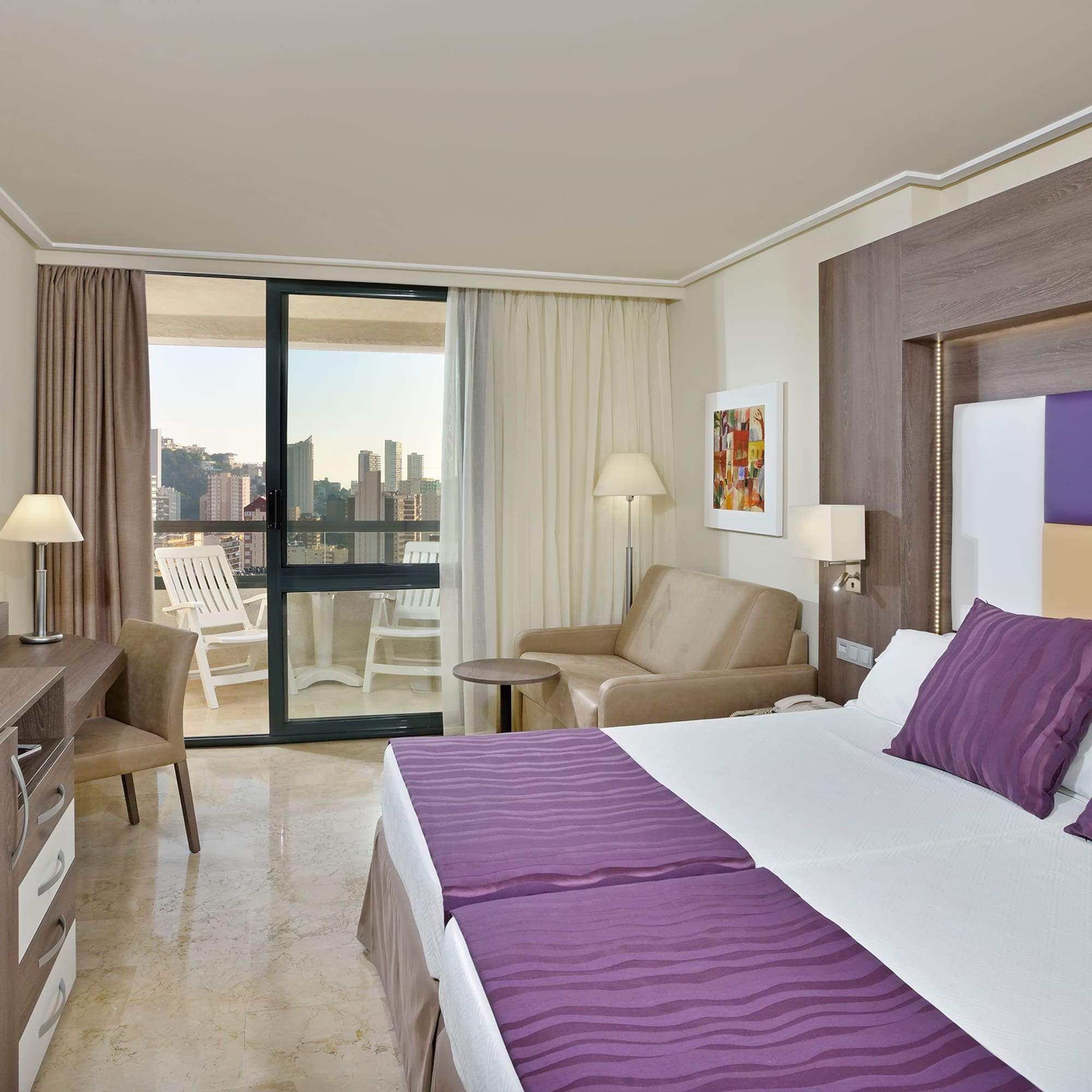 a room with a bed and a chair and a table