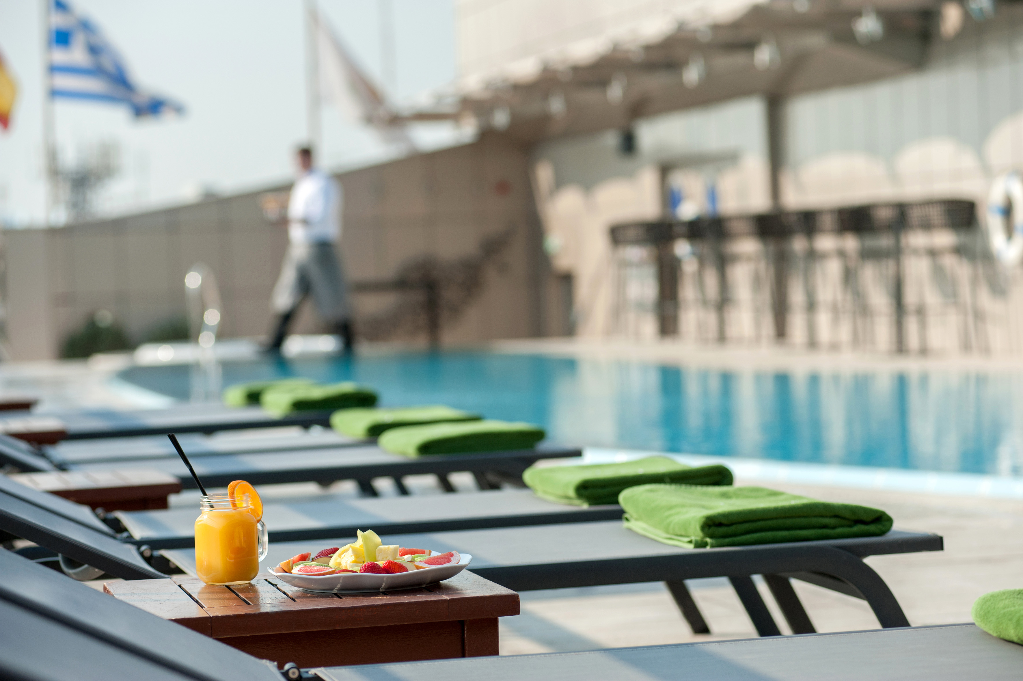 a pool with a drink and a plate of food