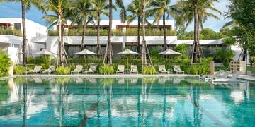a pool with palm trees and chairs