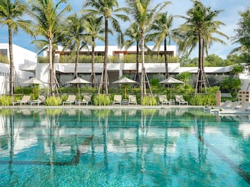 a pool with palm trees and chairs