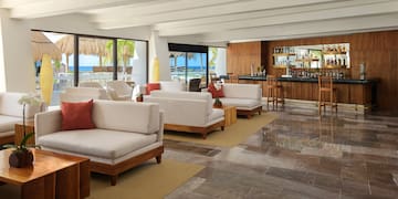 a room with white furniture and a bar