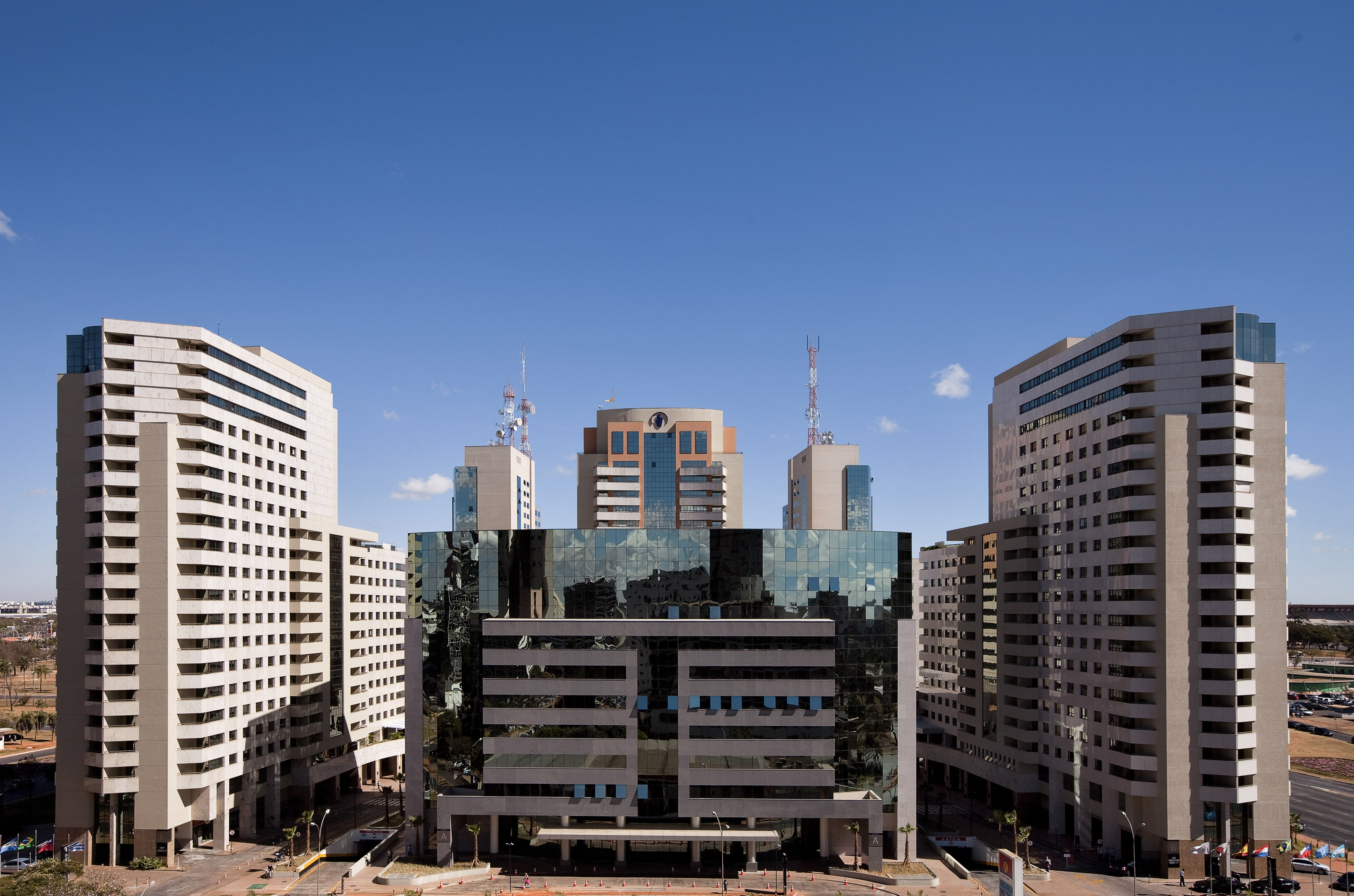 Modern city skyline with tall office buildings and a central reflective glass building.