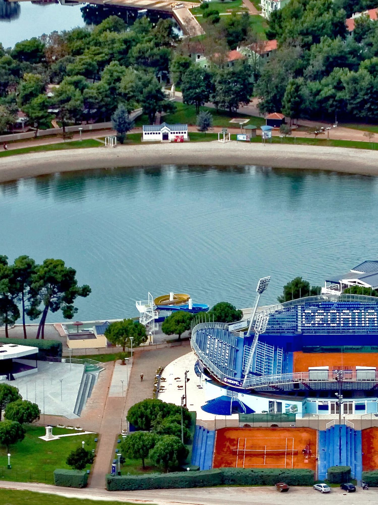 a large body of water with a stadium and trees