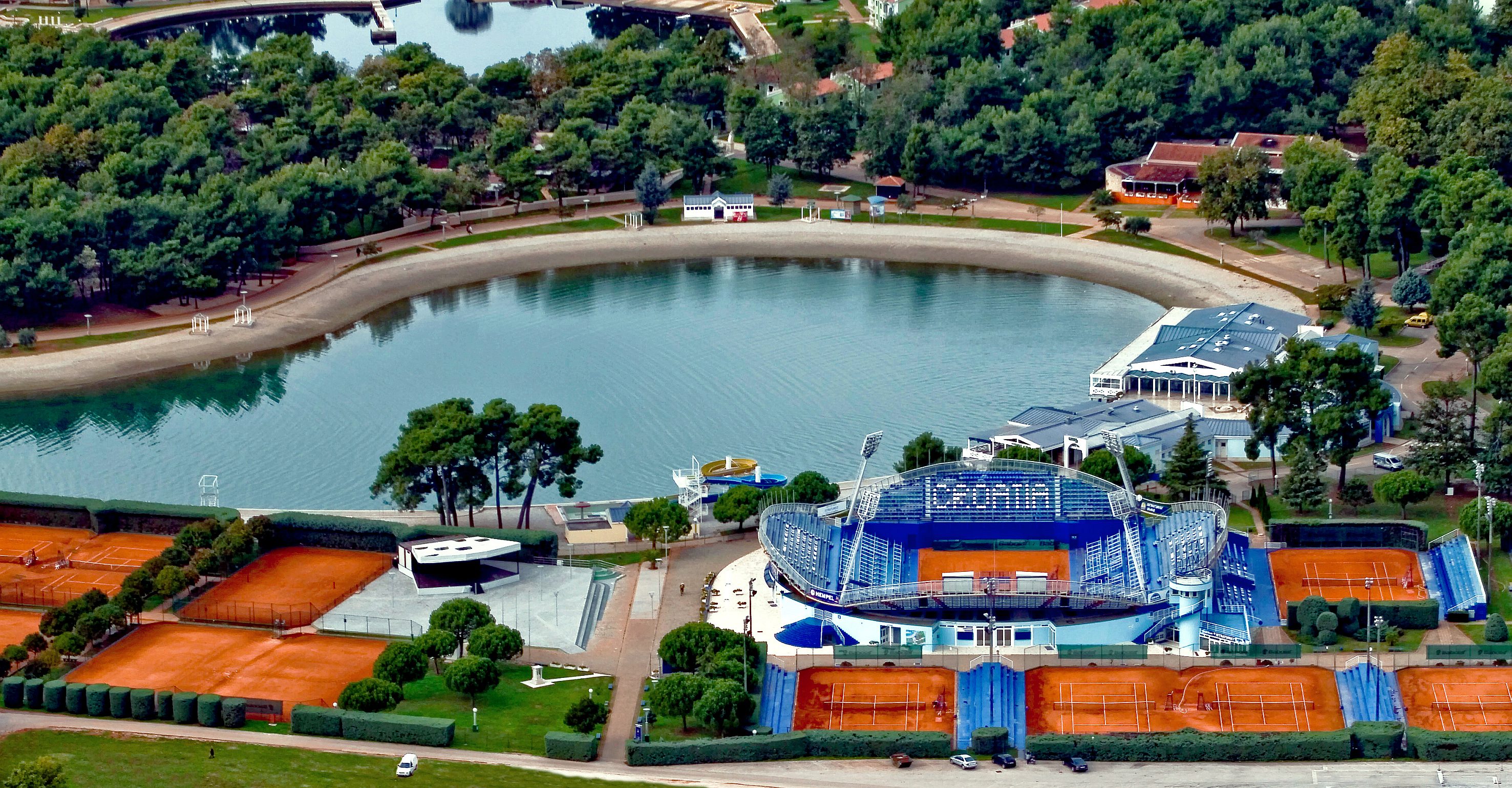 a large body of water with a stadium and trees