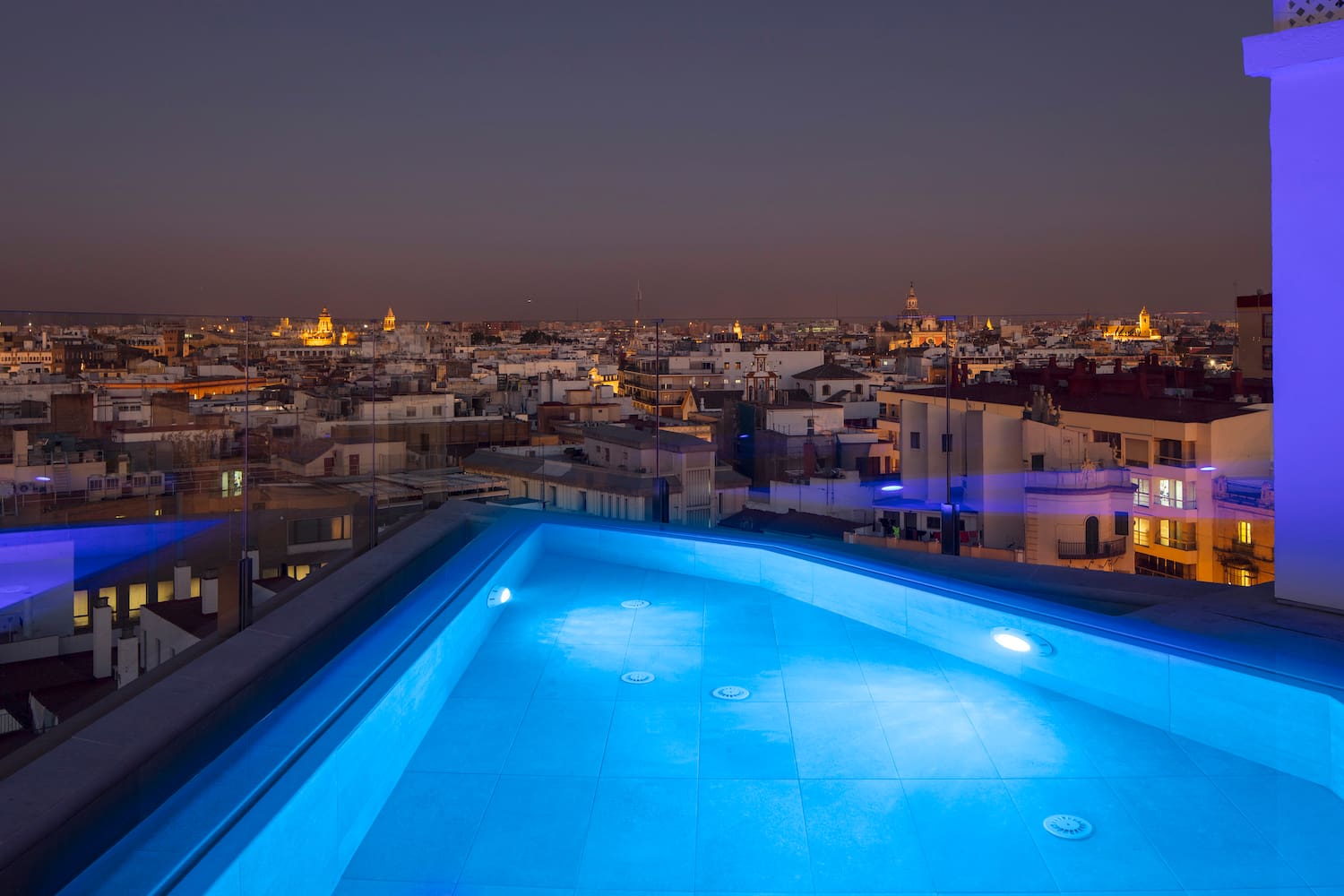 a rooftop pool with lights on