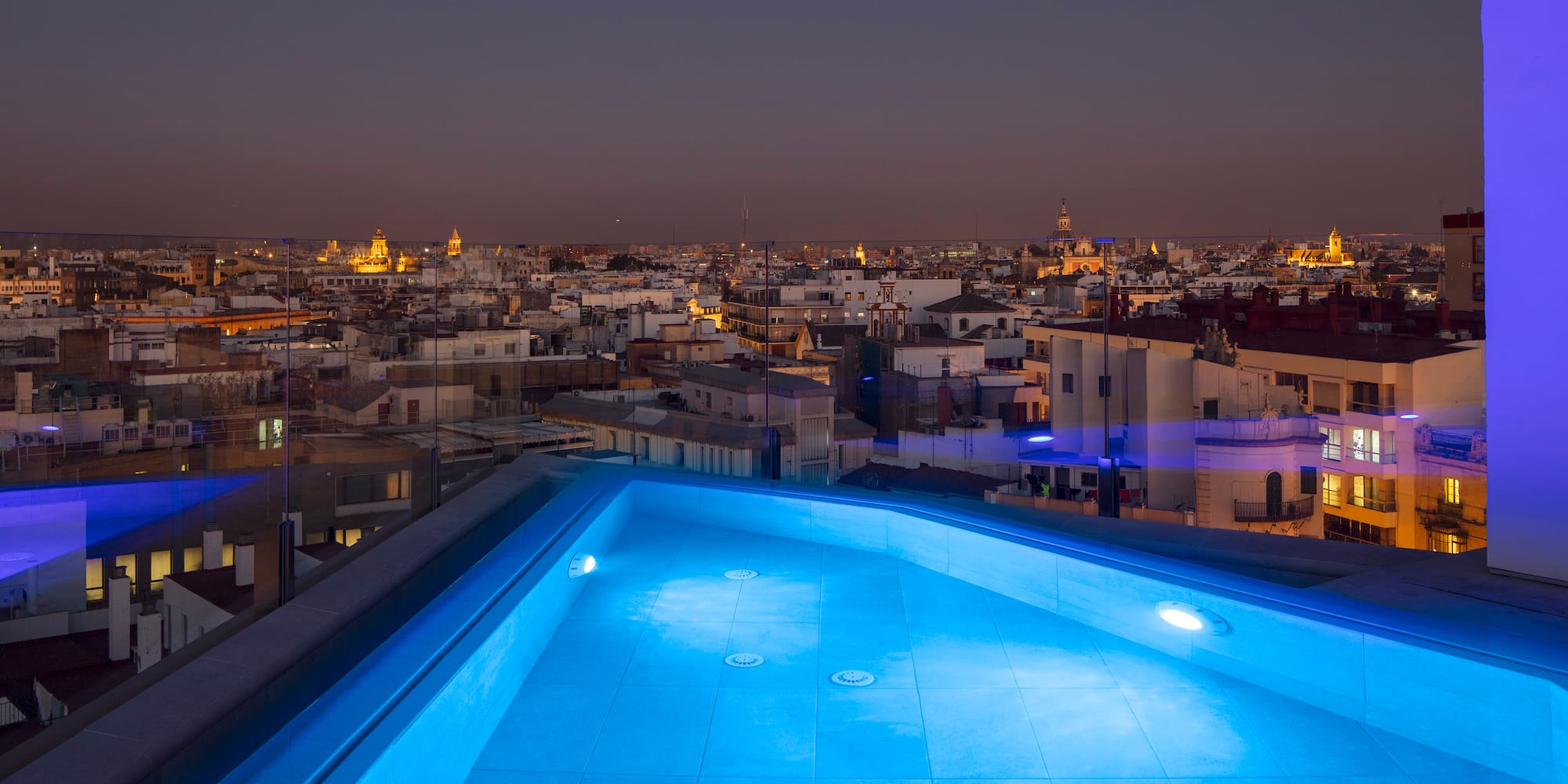 a rooftop pool with lights on