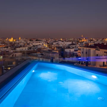 a rooftop pool with lights on