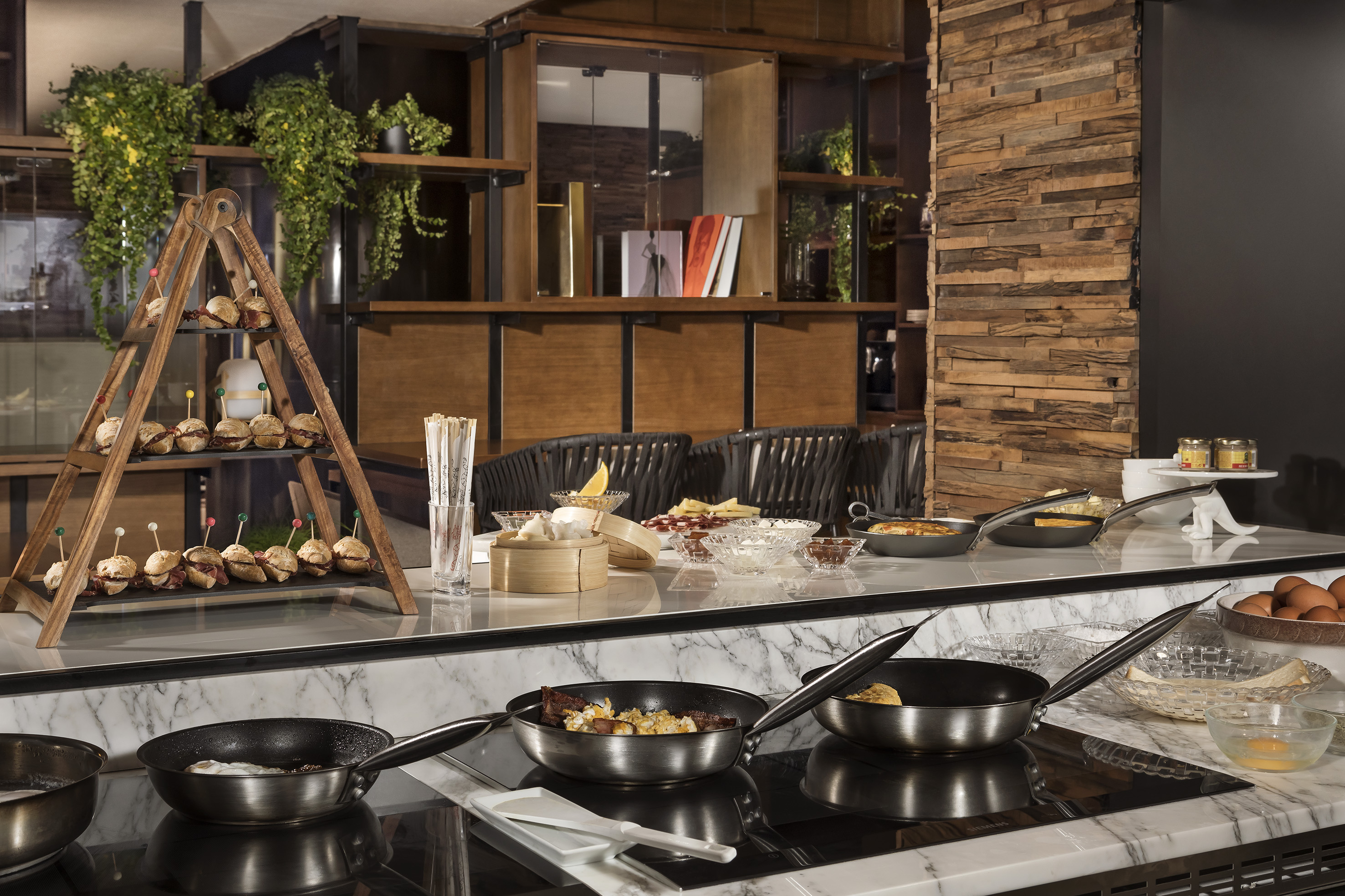 Restaurant breakfast buffet featuring live cooking, mini sliders, and dim sum.