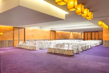 a room with white chairs and a purple carpet
