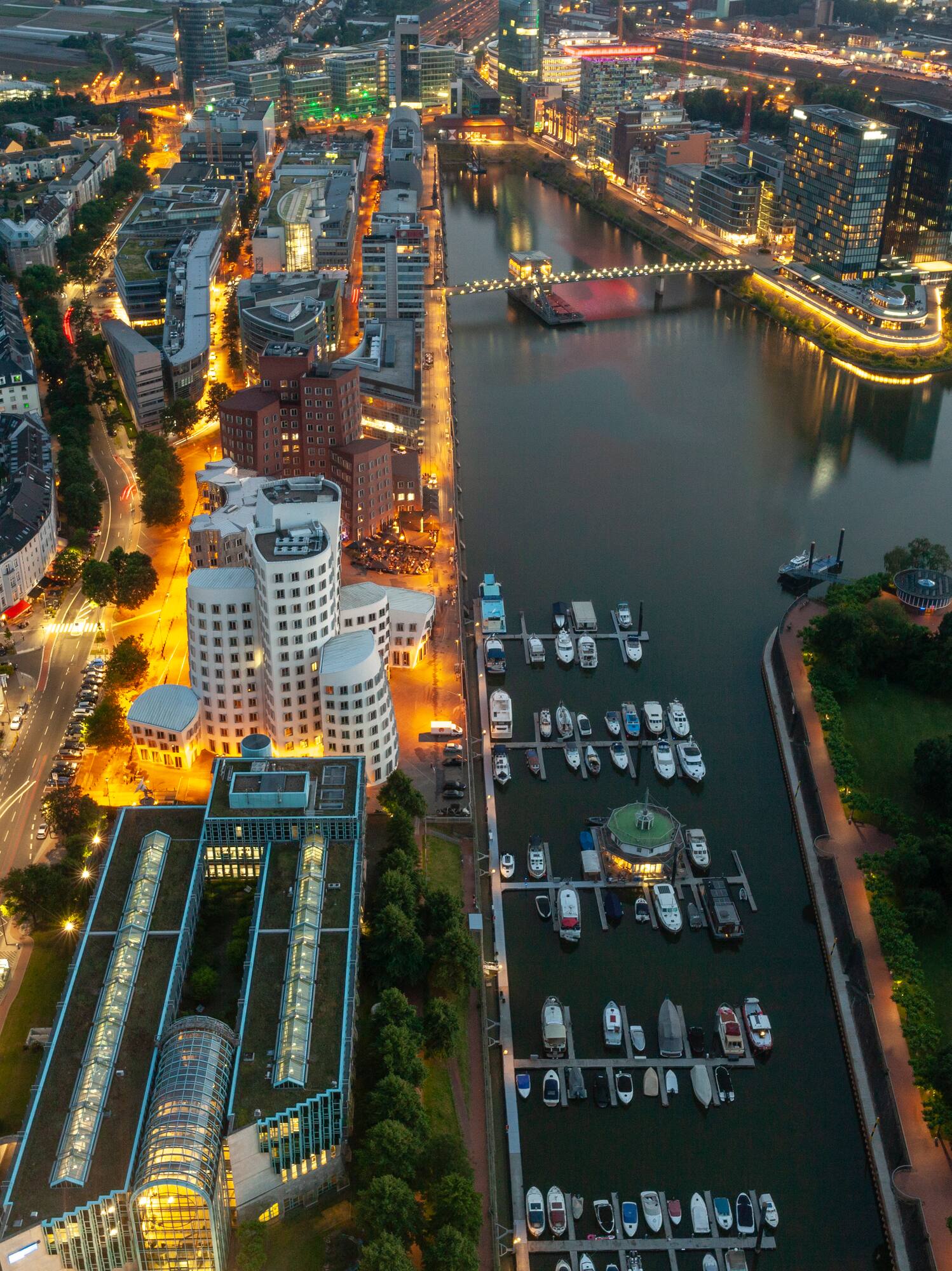 Düsseldorf Media Harbour at night, illuminated modern cityscape with marina.