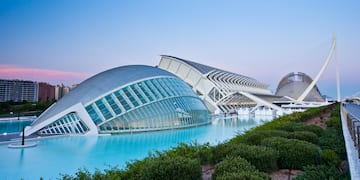a building with a curved roof and a pool of water