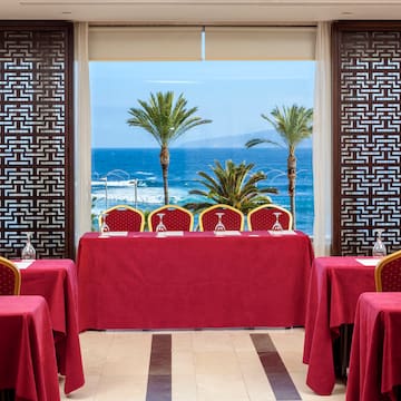 a room with red tablecloths and chairs