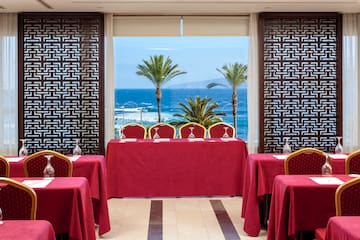 a room with red table cloths and chairs