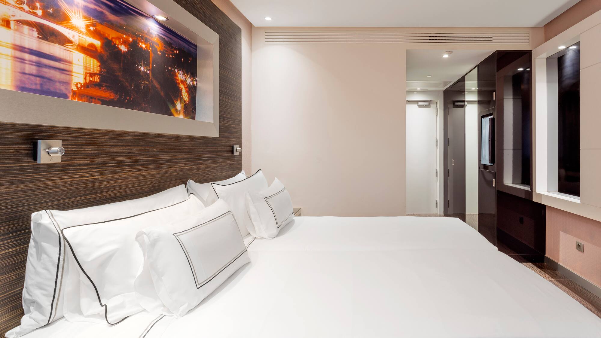 a bed with white sheets and pillows